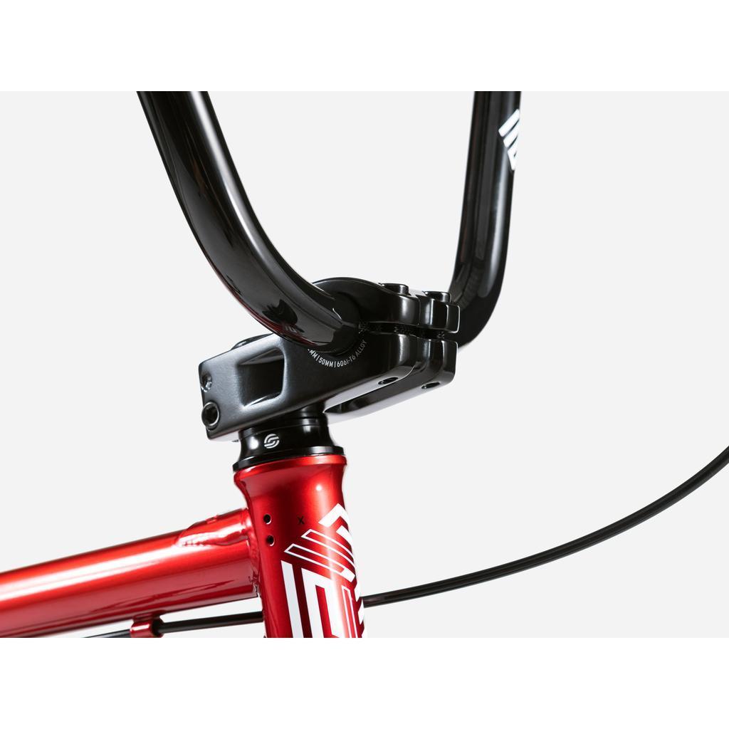 Close-up of the black handlebar and Salt Comp stem on a red Wethepeople Arcade 20 Inch Bike frame with white graphics, set against a plain white background.