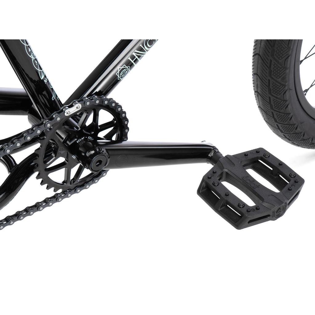 Close-up view of the Wethepeople Havoc 20 Inch Bike’s black crankset, pedal, chainring, and rear tire with a chromo frame against a white background.