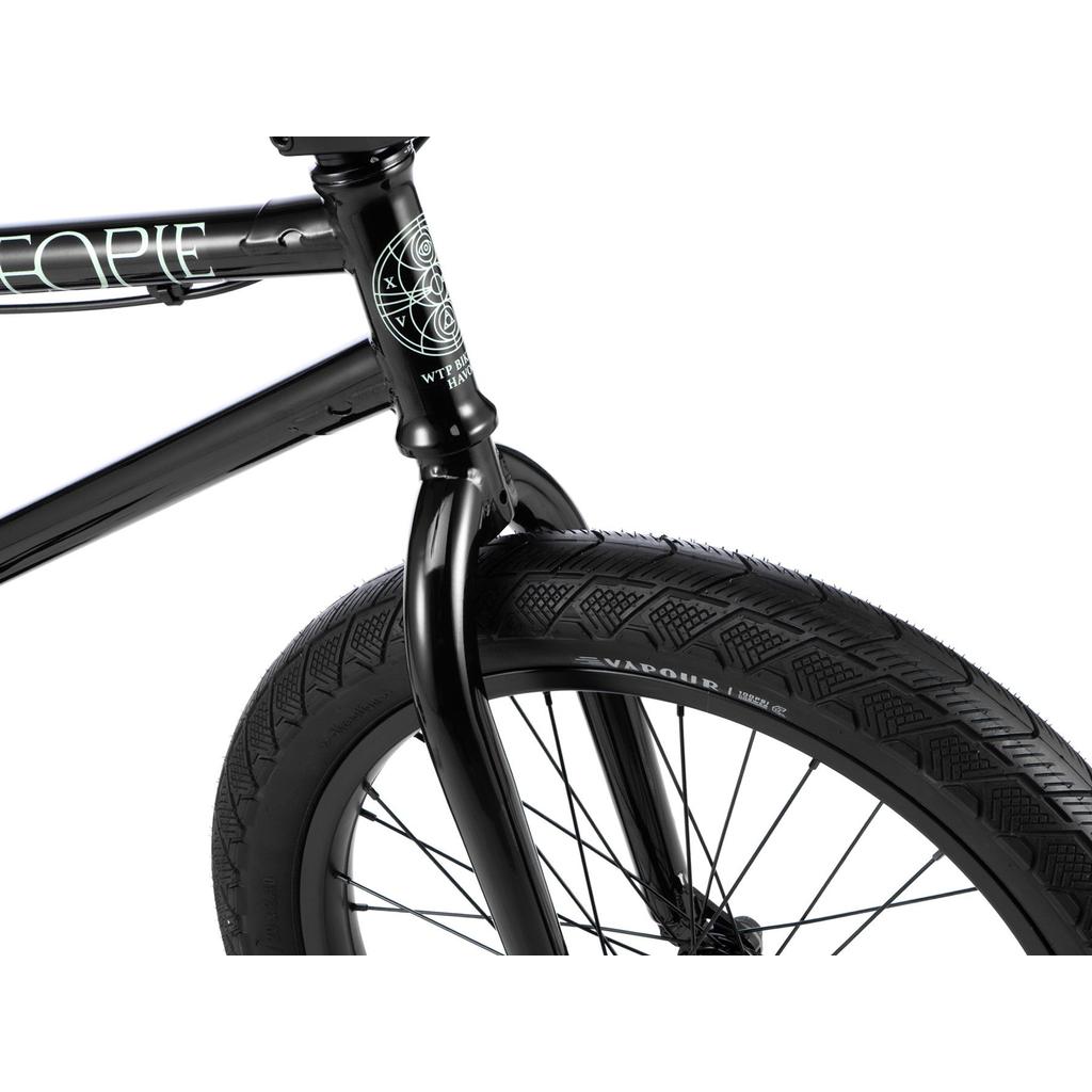Close-up of the front wheel, fork, and part of the Chromo frame on the Wethepeople Havoc 20 Inch Bike, highlighting black tire tread and spoke details against a white background.
