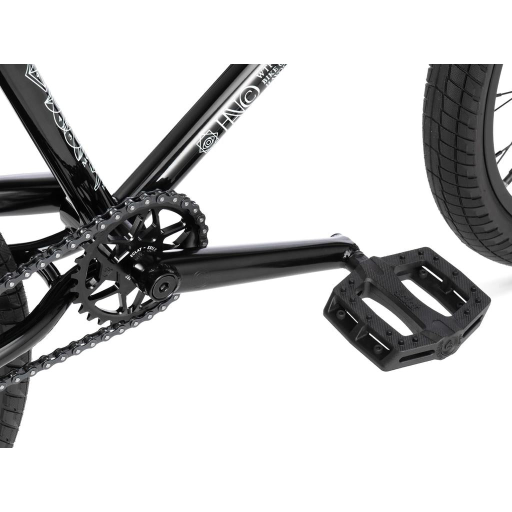 Close-up of a black Wethepeople Havoc 22 Inch Bike's crankset, chainring, pedal, and rear tire against a white background. Disc brake-ready design boosts performance.