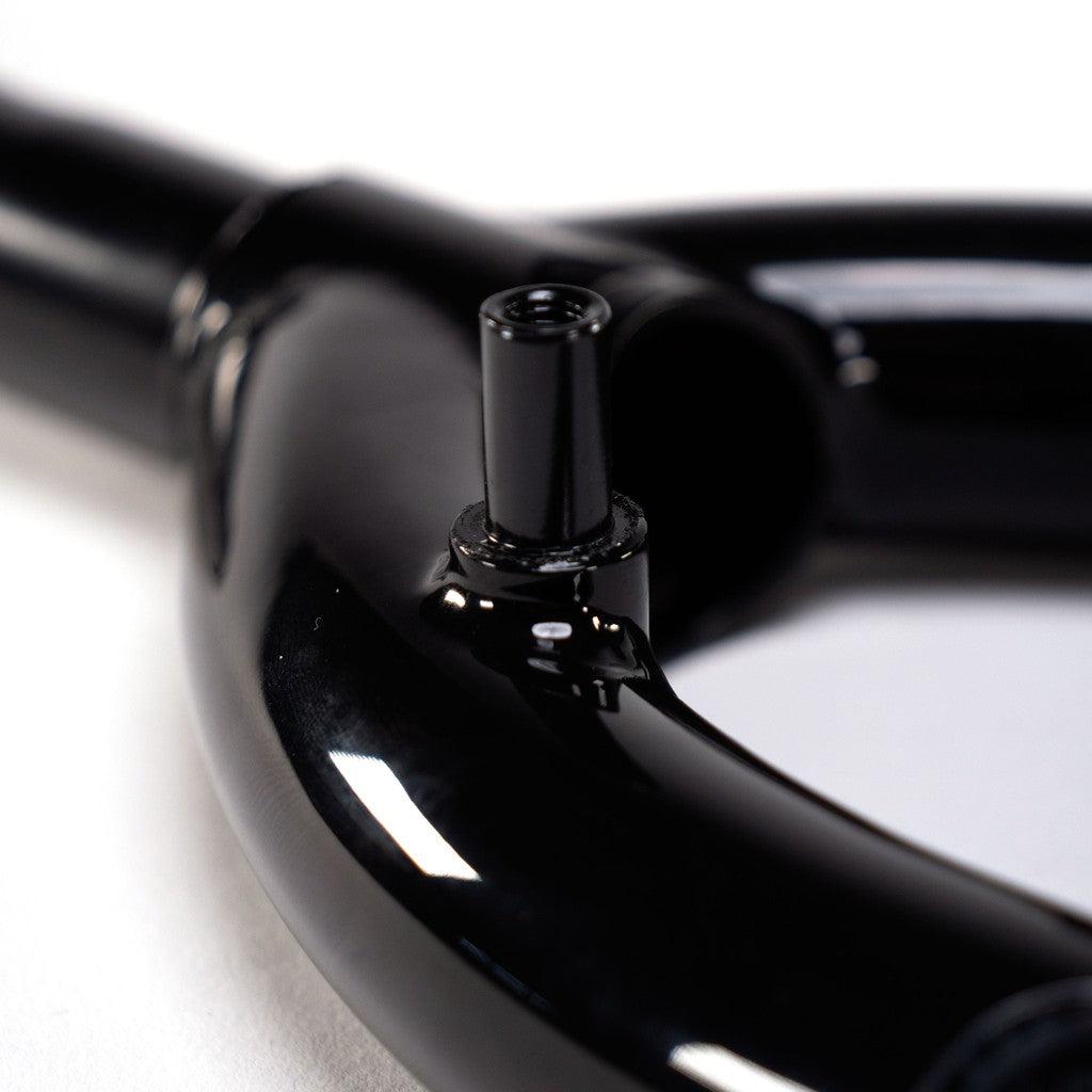 A close up of a black Wethepeople Patron 25 Forks w/Mounts bicycle handlebar with front brake mounts, ideal for riders.