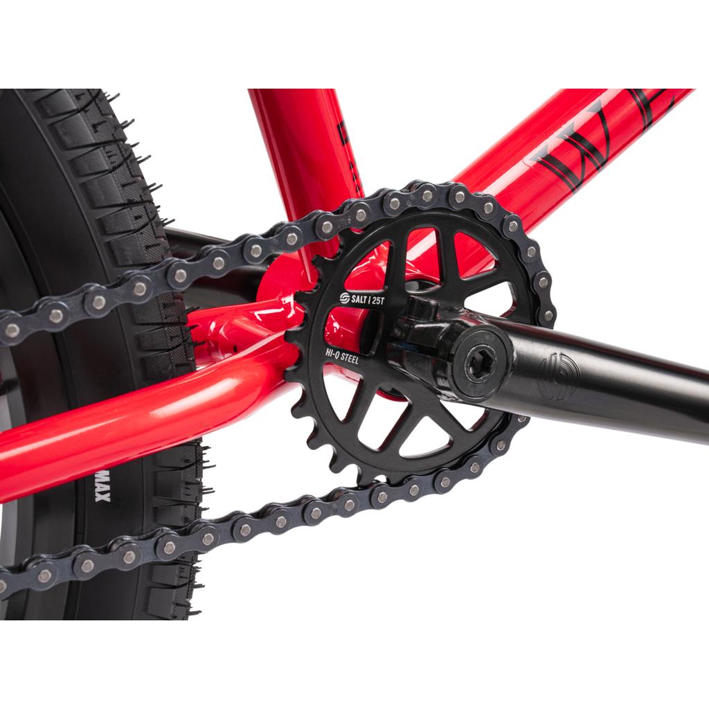 Close-up view of the Wethepeople Thrillseeker 20 Inch Bike’s crankset, chainring, pedal crank, and rear wheel with the chain on the sprocket, highlighting its durable Hi-Ten frame construction.