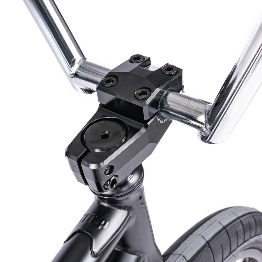Close-up of the Wethepeople Trust 20 Inch Freecoaster/Hybrid Bike's front stem, handlebars, and tire, highlighting its sleek battleship geometry.