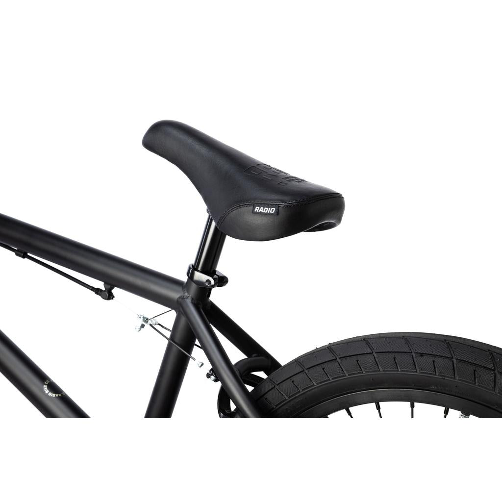 Close-up of a black bicycle seat, seat post, and rear wheel from the Radio Evol XL 20 Inch Bike against a white background.